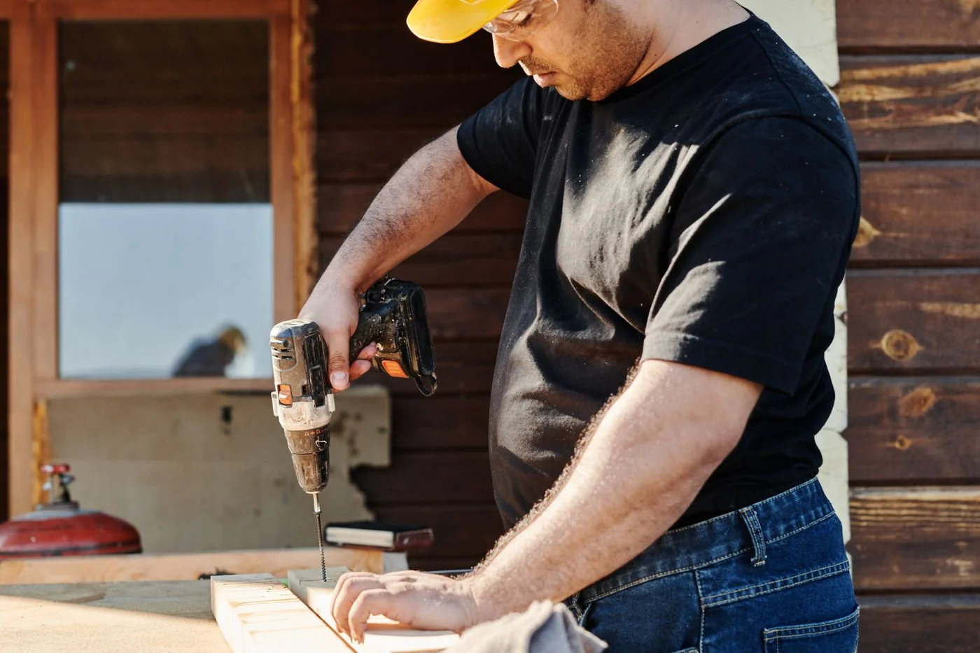 Artisan équipé d’un casque travaillant le bois avec une perceuse — illustration