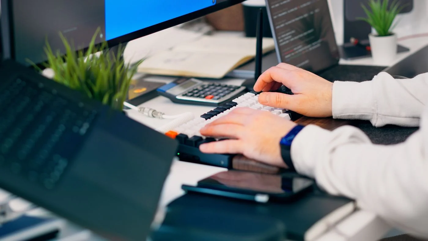 Espace de développement informatique avec clavier, ordinateurs et plantes — illustration